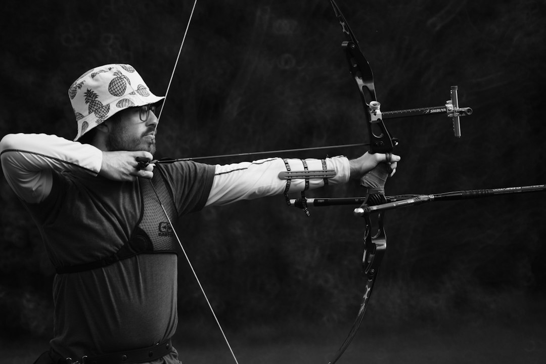 Archer aiming a bow outdoors