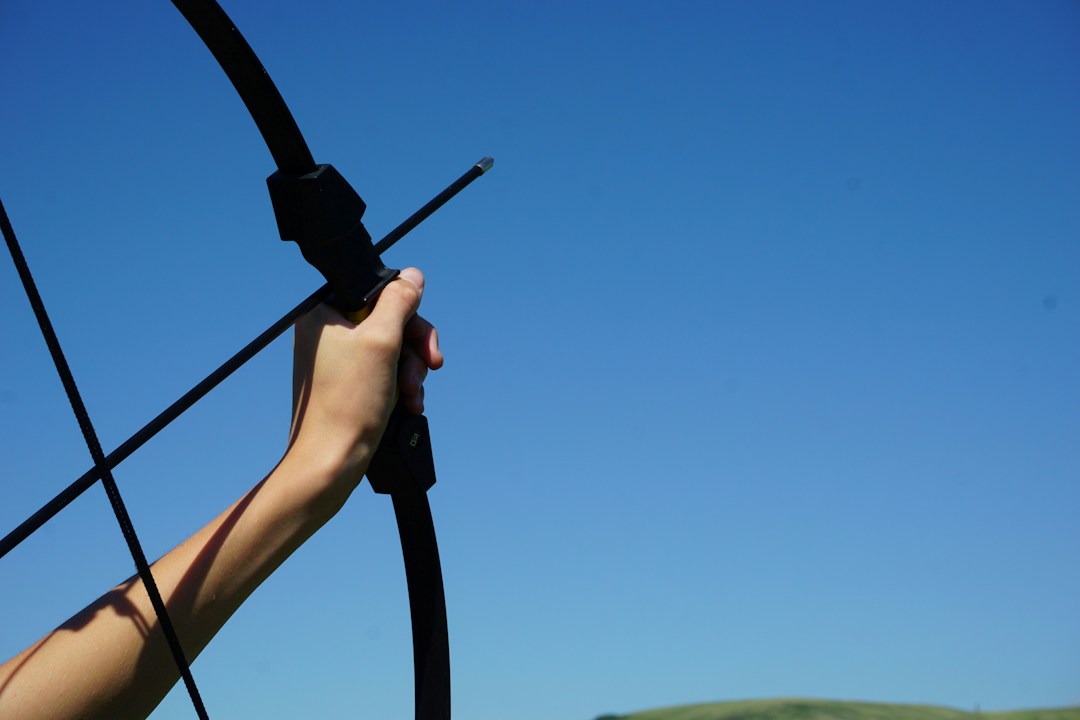 Arrow Fletching Explained: Feathers vs. Vanes and How to Choose 1 Archer holding a bow and arrow outdoors
